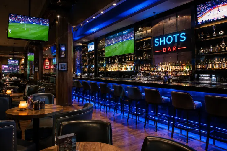 Shots Bar at Hilton Doha featuring large screens for live football match viewing